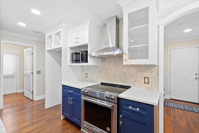 kitchen featuring blue cabinets, appliances with stainless steel finishes, white cabinets, and wall chimney range hood