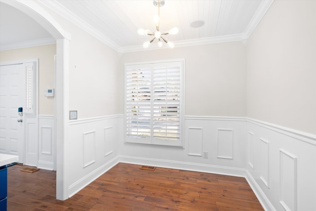 unfurnished dining area featuring visible vents, arched walkways, dark wood-type flooring, wainscoting, and crown molding