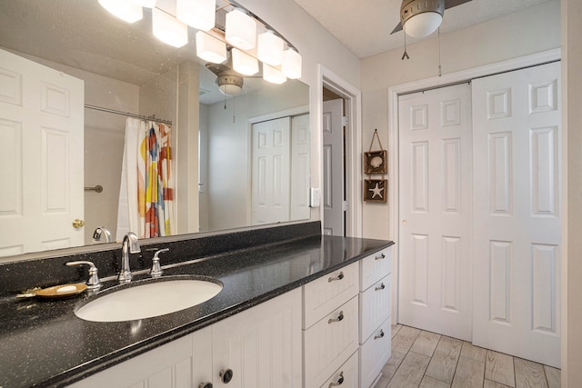 bathroom with vanity, a textured ceiling, wood-type flooring, and walk in shower