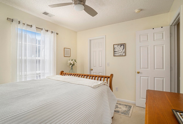 bedroom with light carpet, a textured ceiling, and ceiling fan