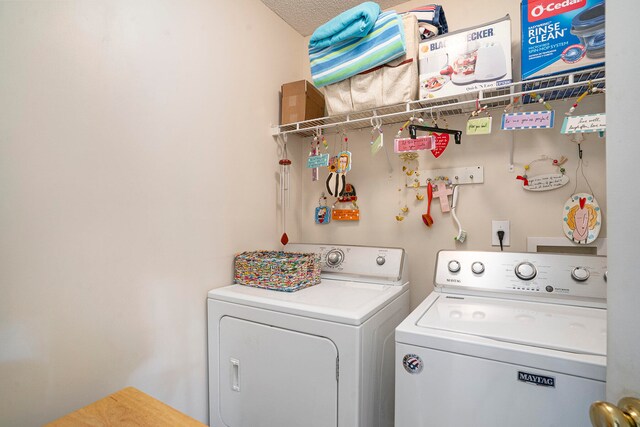 washroom with washer and dryer and a textured ceiling