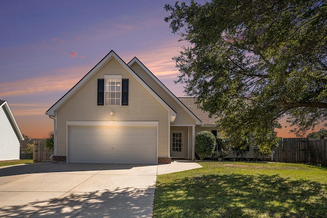 front facade featuring a garage and a lawn