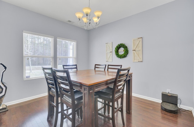 dining space with visible vents, wood finished floors, baseboards, and a chandelier