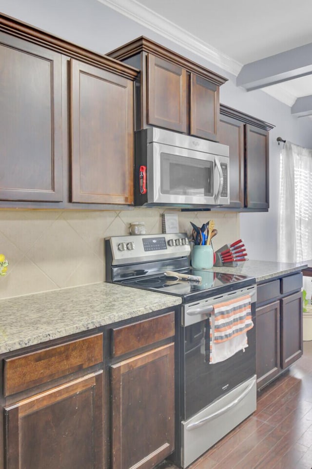 kitchen with backsplash, appliances with stainless steel finishes, dark wood-style floors, and light countertops