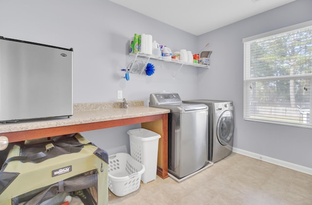 washroom with washer and clothes dryer, laundry area, and baseboards