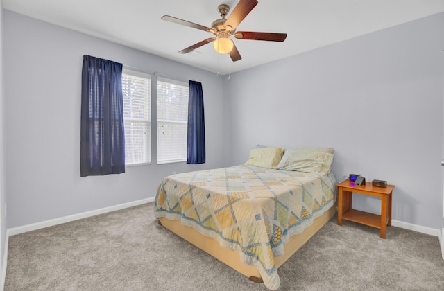 carpeted bedroom with ceiling fan and baseboards