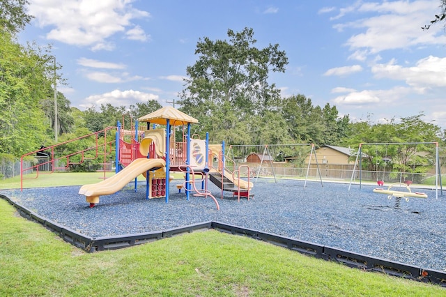 community playground featuring a yard and fence