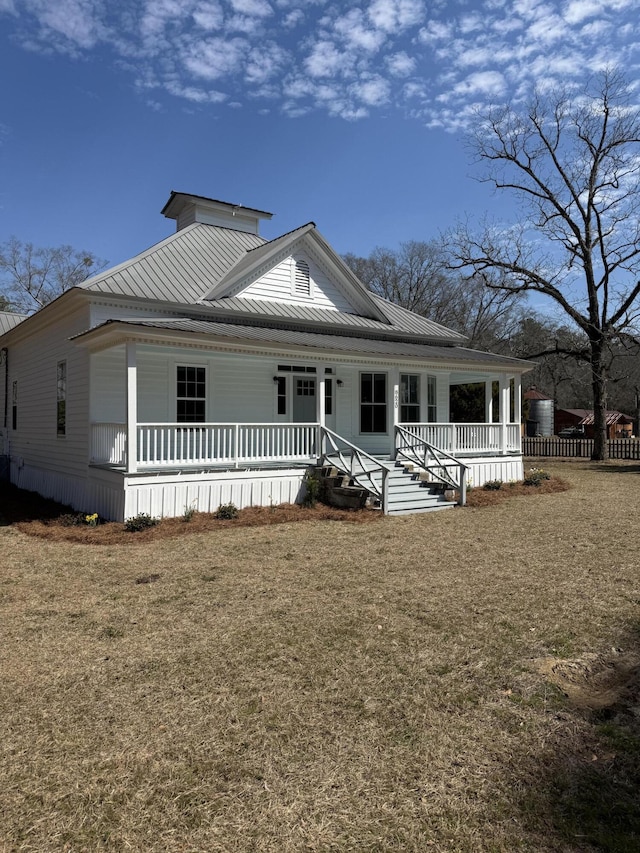 view of front of home featuring a porch, a front yard, and metal roof