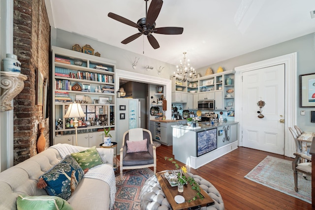 living room featuring ceiling fan with notable chandelier and dark hardwood / wood-style floors