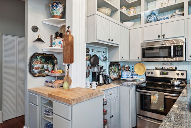 kitchen featuring wood counters, white cabinetry, and stainless steel appliances