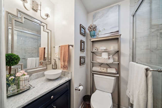 bathroom with vanity, a shower with door, and toilet