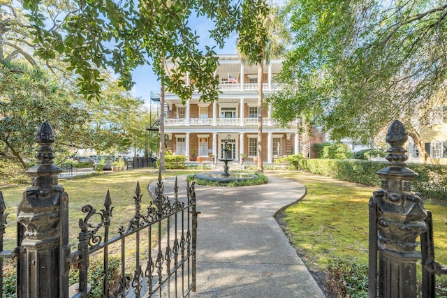 neoclassical home featuring a front yard and a balcony