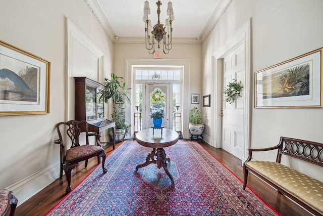 foyer featuring crown molding, a notable chandelier, and hardwood / wood-style flooring