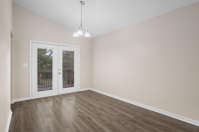 unfurnished dining area with lofted ceiling, a notable chandelier, dark wood-type flooring, and french doors