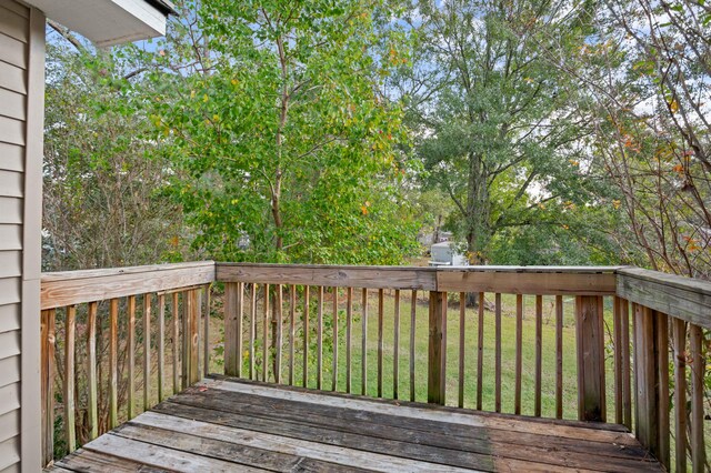 wooden terrace featuring a lawn