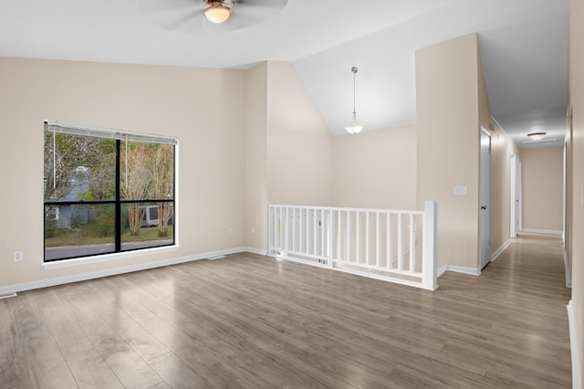 unfurnished room with wood-type flooring, ceiling fan, and vaulted ceiling