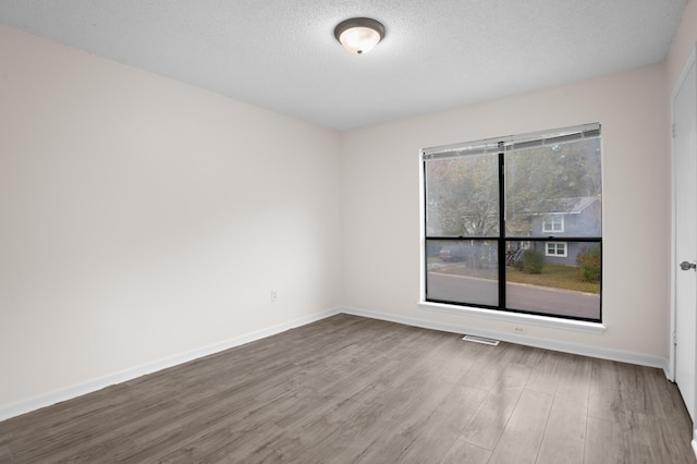 empty room featuring hardwood / wood-style floors and a textured ceiling