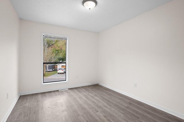 spare room with hardwood / wood-style floors and a textured ceiling