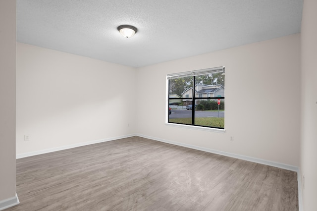 unfurnished room featuring wood-type flooring and a textured ceiling