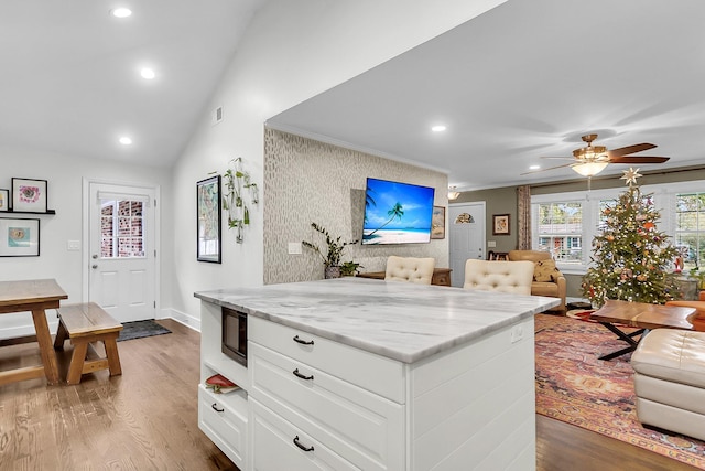 kitchen featuring light stone countertops, ceiling fan, dark hardwood / wood-style flooring, and white cabinetry