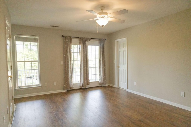 spare room with a ceiling fan, a healthy amount of sunlight, and wood finished floors