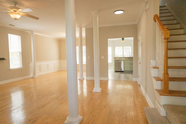 interior space featuring crown molding, stairway, ornate columns, and light wood-style flooring