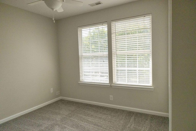 carpeted spare room with baseboards, a ceiling fan, and visible vents