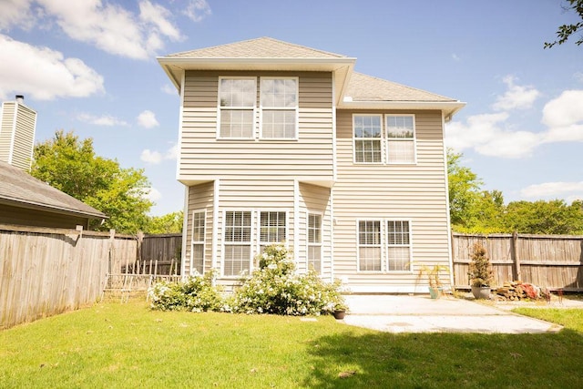 back of property featuring a lawn, a patio, a fenced backyard, and roof with shingles