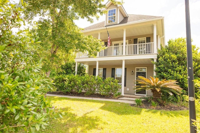 back of property with a porch, a yard, and a balcony