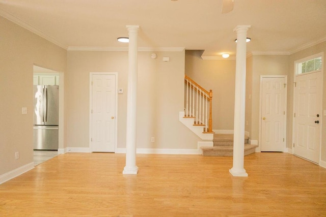 foyer featuring crown molding, stairway, and wood finished floors