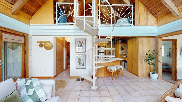 interior space featuring wood walls, light tile patterned flooring, wooden ceiling, and high vaulted ceiling