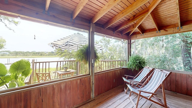 unfurnished sunroom with vaulted ceiling with beams, a water view, and wood ceiling