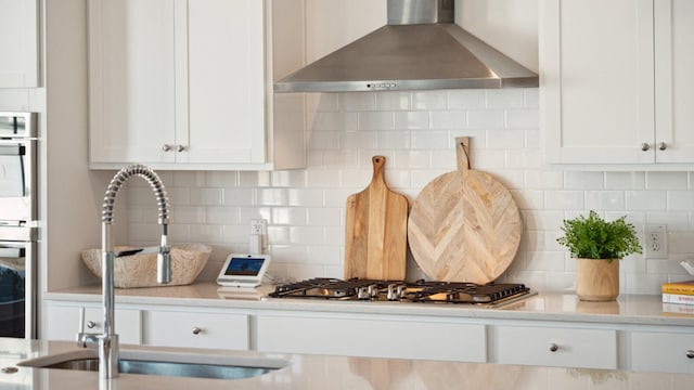 304 Archar St, Summerville, SC 29486 - kitchen featuring wall chimney exhaust hood, decorative backsplash, white cabinets, and stainless steel gas stovetop