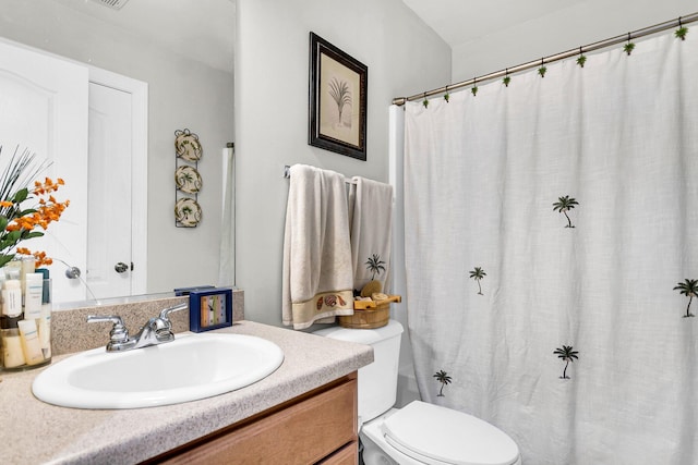 bathroom featuring curtained shower, toilet, and vanity