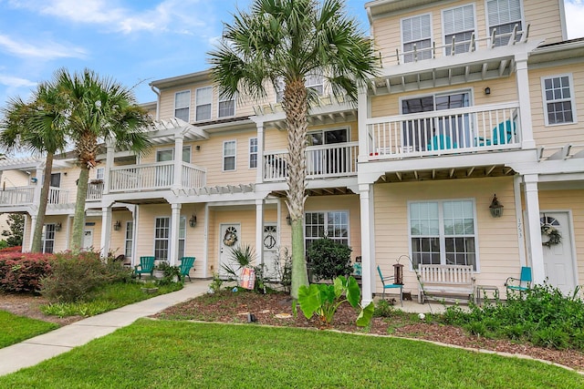 view of front of property with a balcony and a front lawn