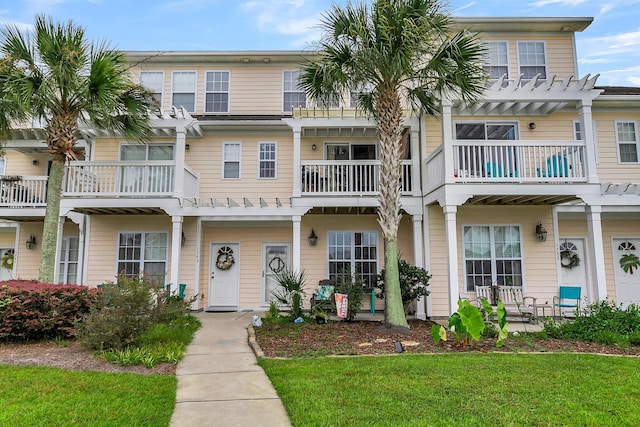 view of property featuring a front lawn and a balcony