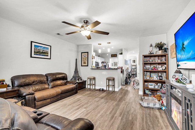 living room with ceiling fan and light hardwood / wood-style floors