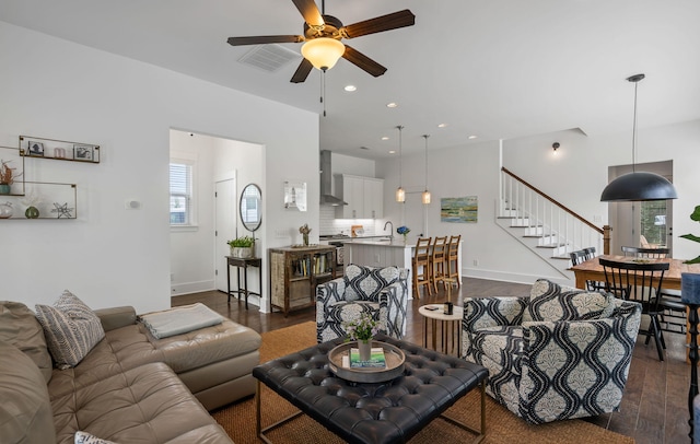 living room with dark wood-type flooring, ceiling fan, and sink