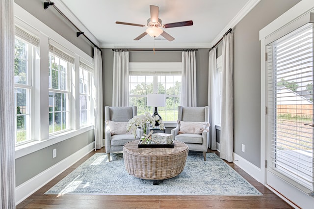 living area featuring dark hardwood / wood-style flooring, ceiling fan, and crown molding