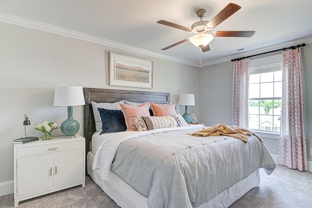 carpeted bedroom with ceiling fan and ornamental molding