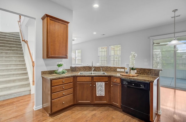 334 Cicadas Song Dr, Moncks Corner, SC 29461 - kitchen with dishwasher, a sink, brown cabinets, light wood-type flooring, and dark stone counters
