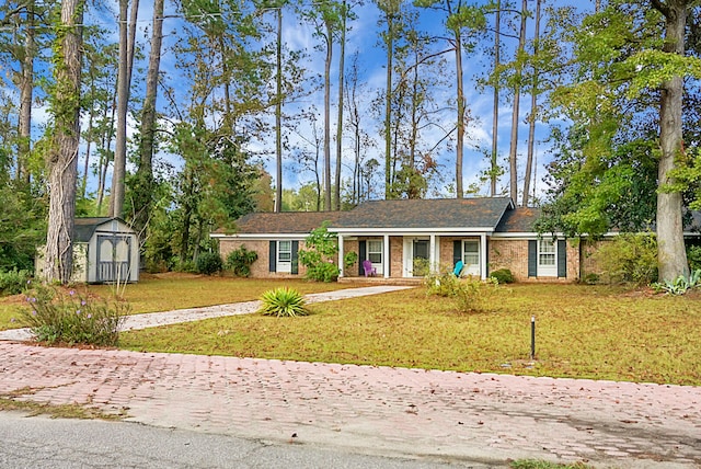 single story home featuring a front lawn and a storage unit