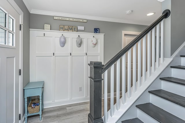 staircase featuring recessed lighting, wood finished floors, and crown molding