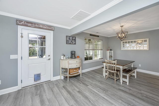 dining room featuring wood finished floors, baseboards, visible vents, an inviting chandelier, and ornamental molding