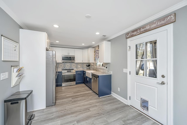 kitchen with blue cabinetry, backsplash, appliances with stainless steel finishes, and ornamental molding