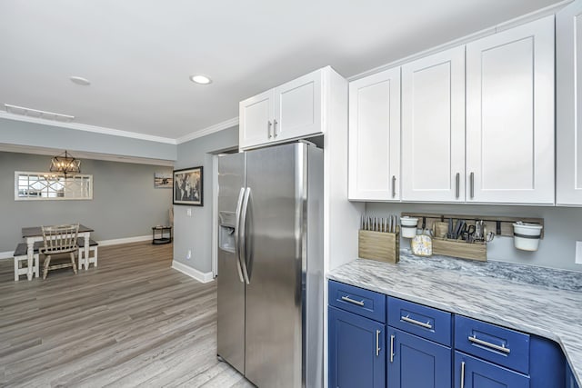 kitchen with light wood-style flooring, white cabinets, stainless steel fridge with ice dispenser, crown molding, and baseboards