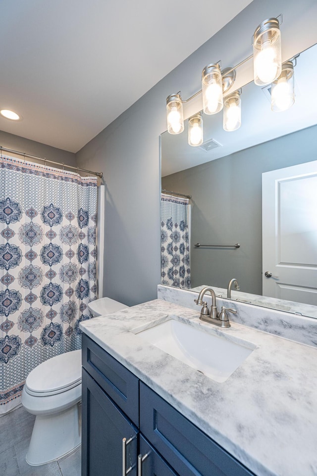 bathroom featuring vanity, a shower with curtain, visible vents, tile patterned floors, and toilet