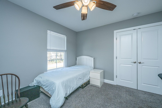 carpeted bedroom with a closet, baseboards, and ceiling fan