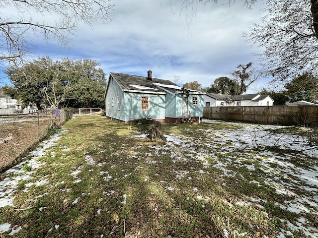 view of snow covered back of property