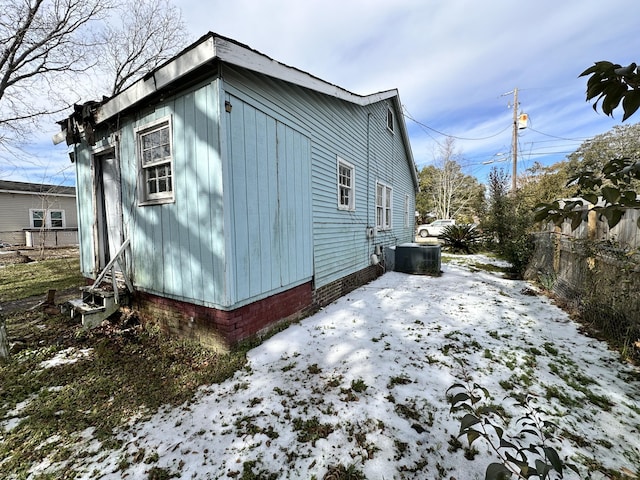 view of snowy exterior with central air condition unit